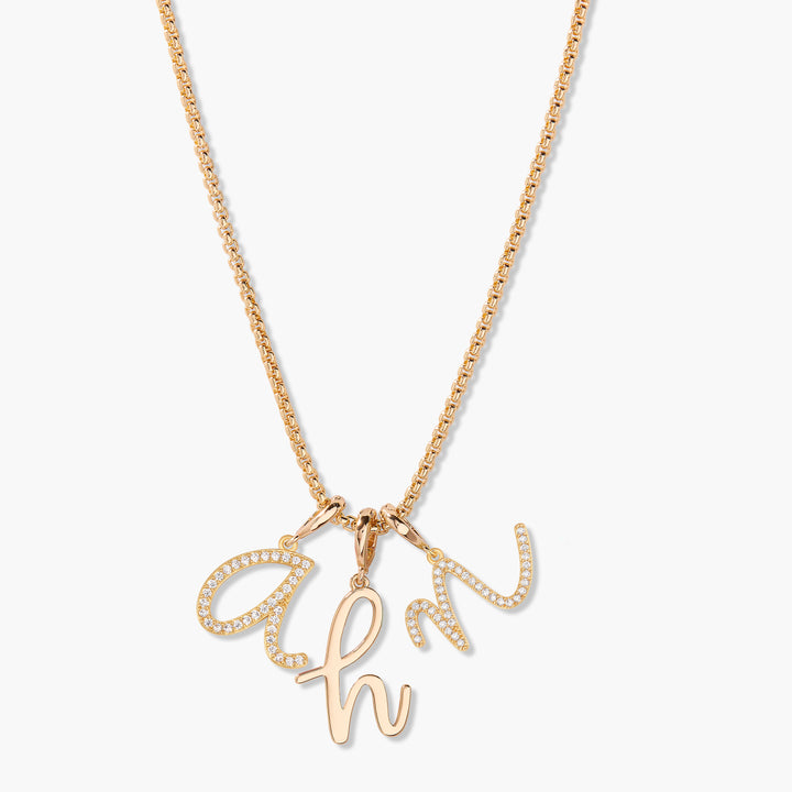 Waverly Initial Necklace with three cursive script initial charms pavé-set with white stones on a chain.