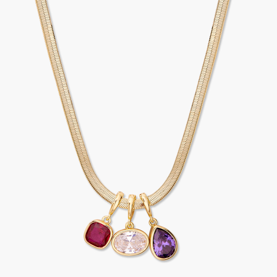 Gold-tone chain necklace with three bezel-set birthstone charms in square, oval, and teardrop shapes sliding along the chain.