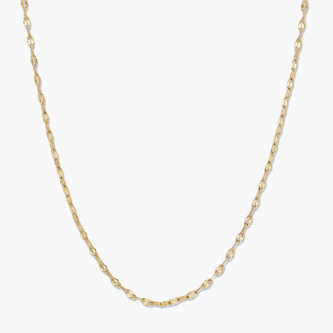 Celine Necklace, a delicate gold-tone chain with flat, oval mirrored links that catch the light beautifully.