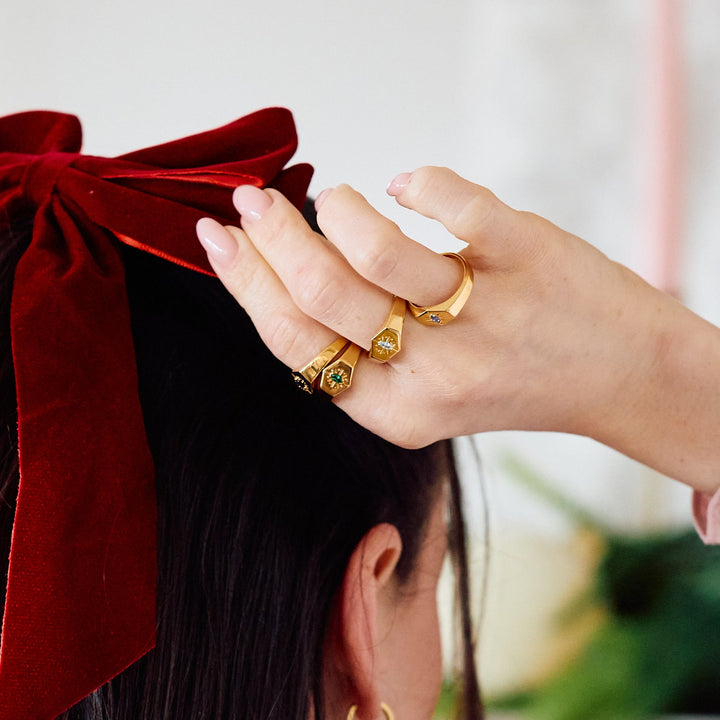 Birthstone Signet rings with hexagonal faces and starburst engraving, each set with a different-colored marquise stone on a women&