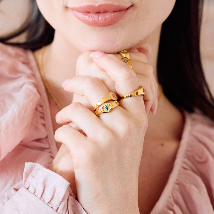 Birthstone Signet rings with hexagonal faces and starburst engraving, each set with a different-colored marquise stone on a women&